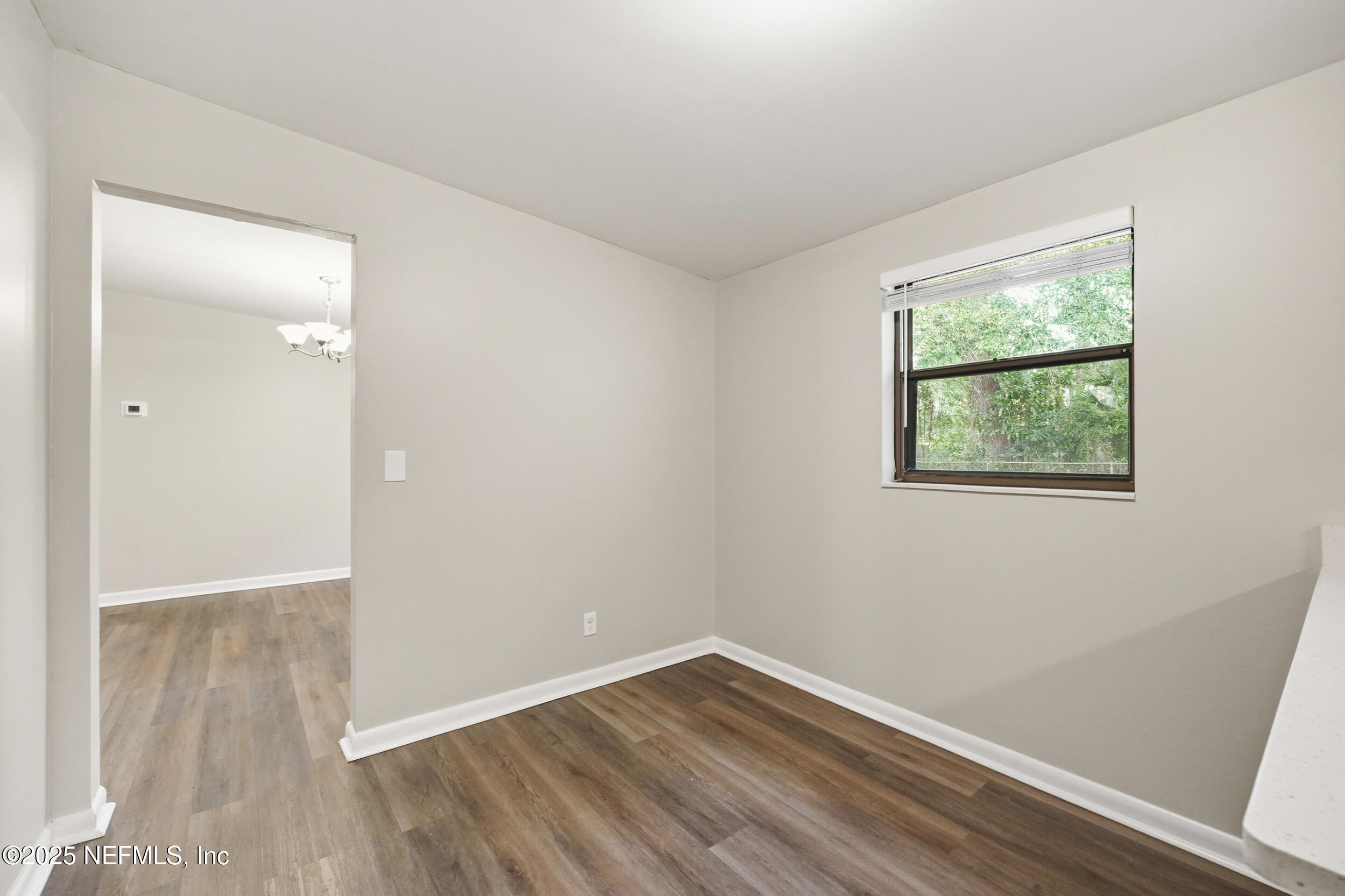 3135 Victoria Park Road Jacksonville, FL 32216 - Photo 7 of 21 an empty room with wooden floor and windows