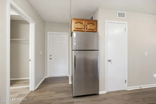 a white refrigerator freezer and a wooden floor