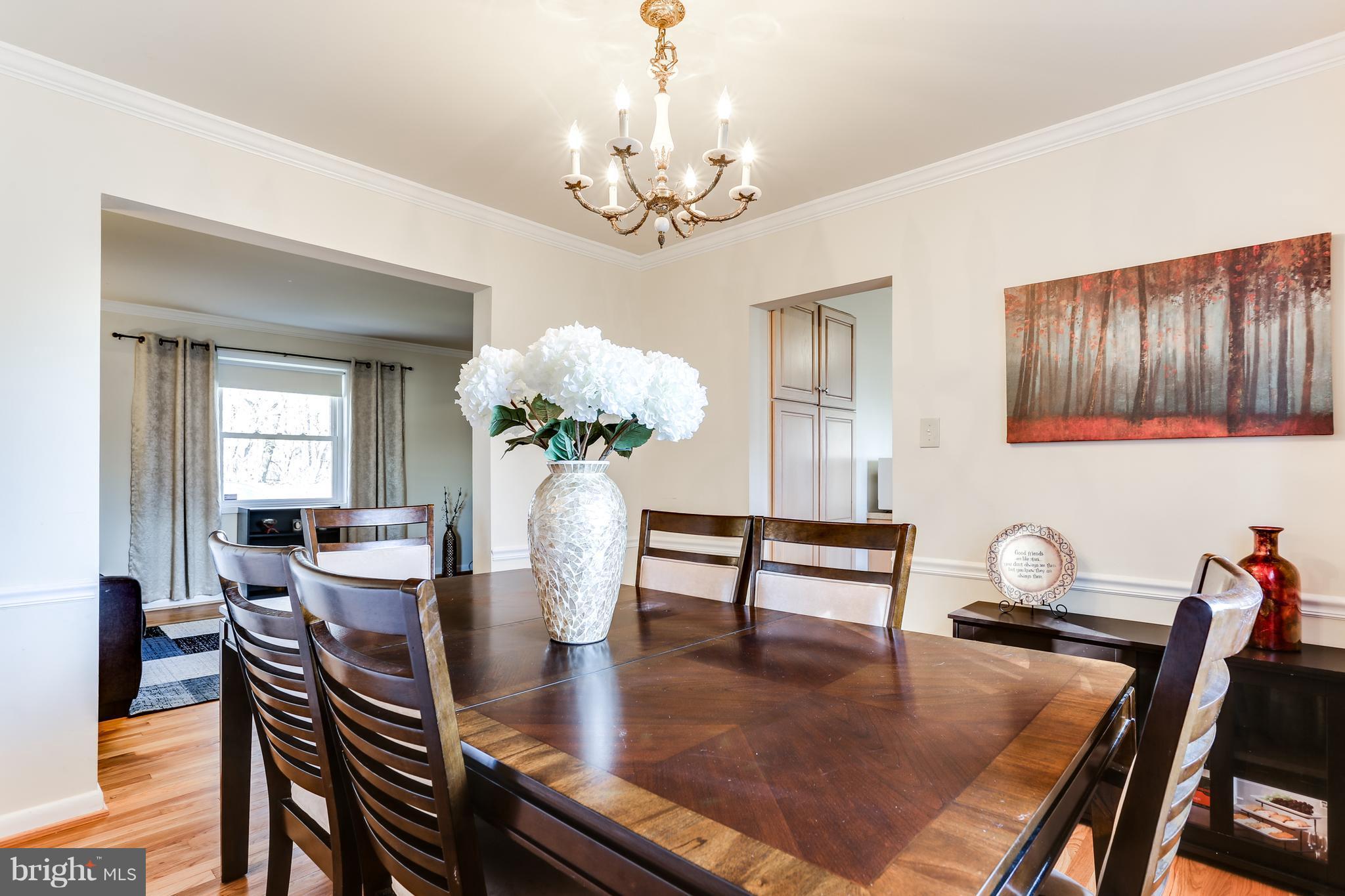 9003 Winands Road Owings Mills, MD 21117 - Photo 6 of 30 a dining room with furniture a chandelier and wooden floor