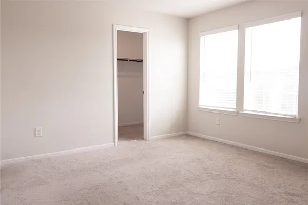 an empty room with windows and closet