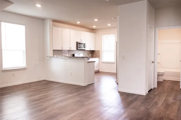 a kitchen with stainless steel appliances granite countertop a sink stove and wooden floor