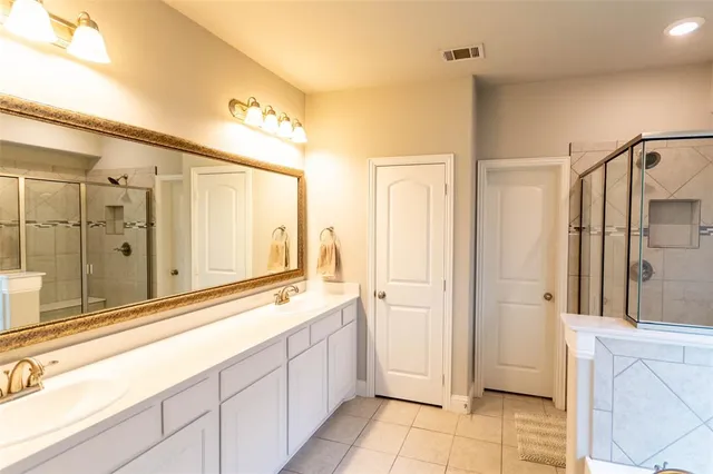 a bathroom with a tub a sink a mirror and a shower