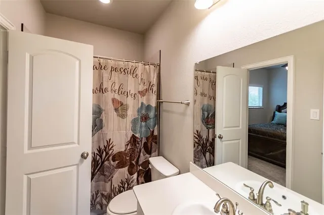 a bathroom with a sink toilet and shower