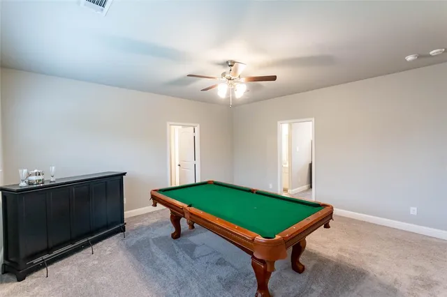 a room with pool table and windows