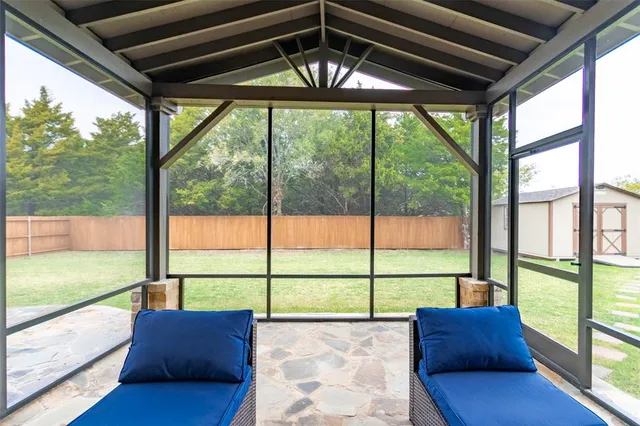 a view of a porch with furniture and a yard