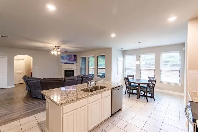a kitchen with granite countertop a sink and chairs
