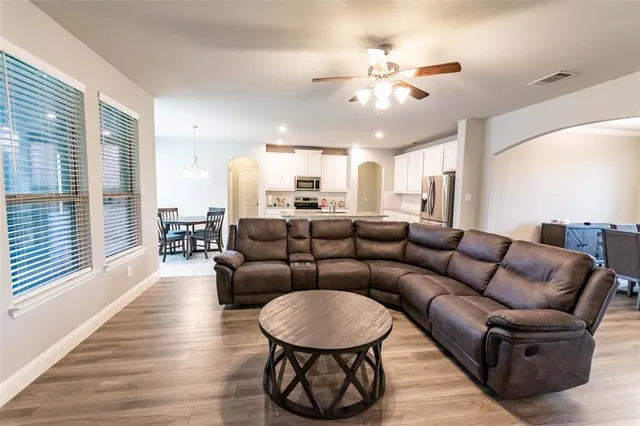 a living room with furniture kitchen and a large window