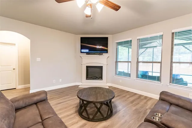 a living room with furniture a flat screen tv and a fireplace
