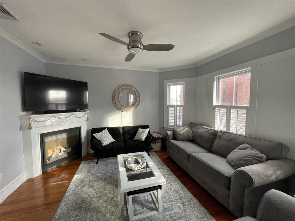 a living room with furniture a flat screen tv and a fireplace