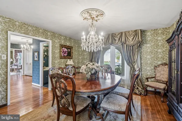 a view of a dining room with furniture a chandelier and wooden floor