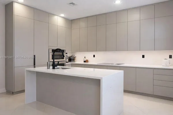 a room with a sink cabinets and washer