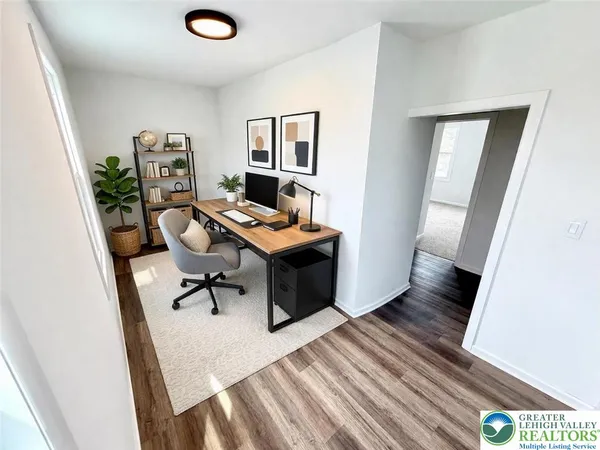 a view of a workspace with furniture and wooden floor