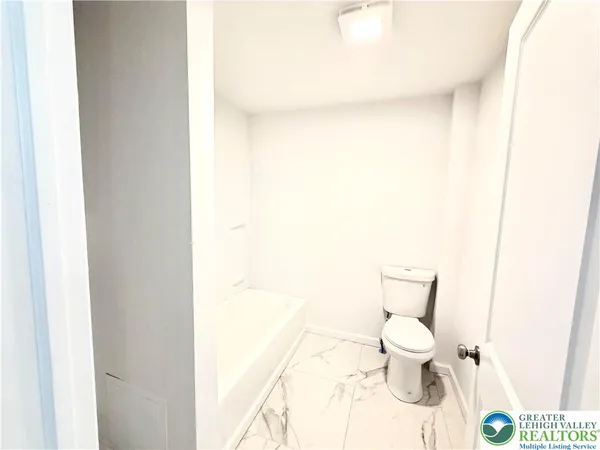 a white toilet sitting next to a white sink