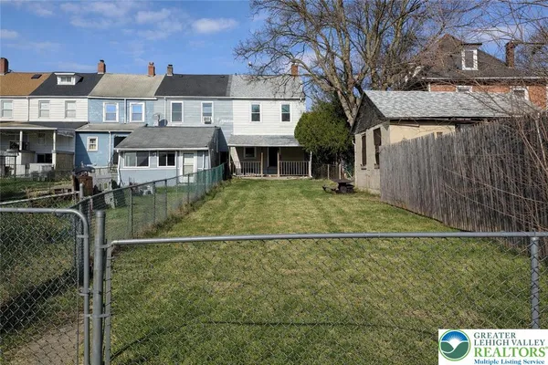 a view of a white house with a yard