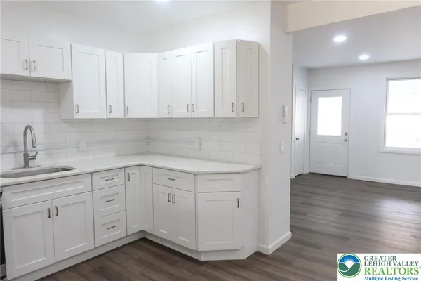 a kitchen with white cabinets appliances and a sink