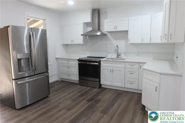 a kitchen with stainless steel appliances granite countertop a refrigerator and a stove top oven
