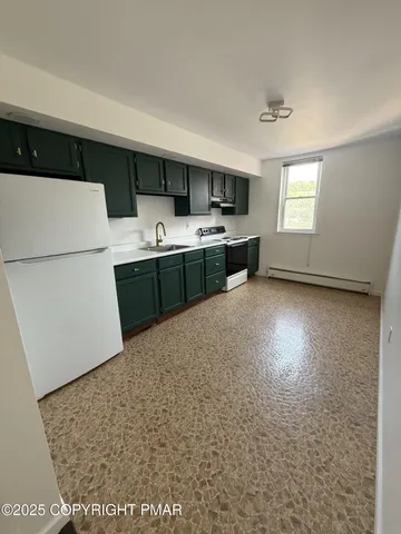 a kitchen with stainless steel appliances a refrigerator and a stove top oven