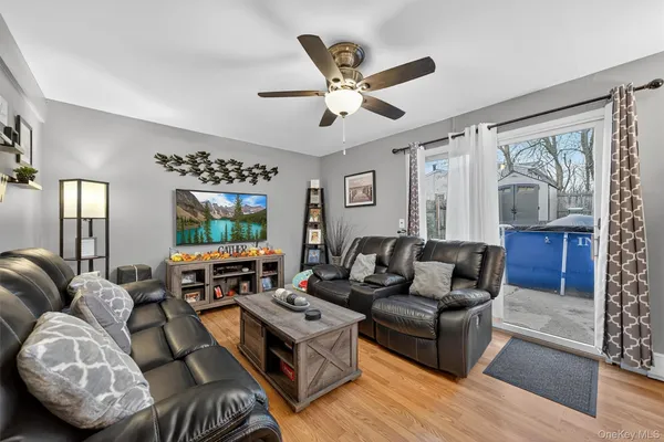 a living room with furniture ceiling fan and a window