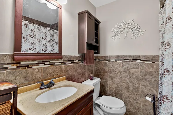 a bathroom with a sink toilet and a mirror