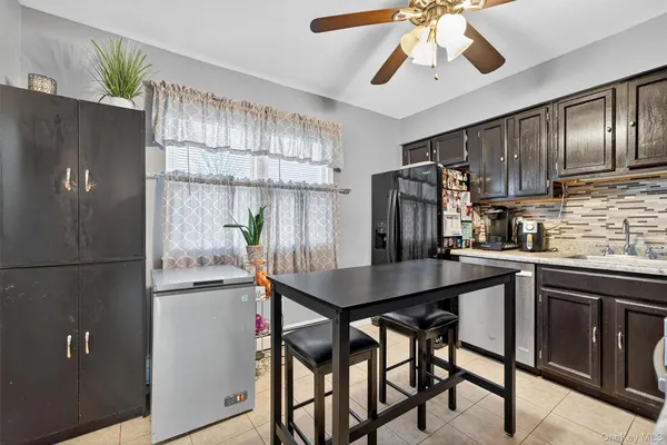 a kitchen with stainless steel appliances a refrigerator a sink a stove a dining table and chairs