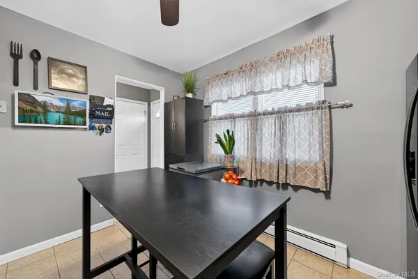 a kitchen with stainless steel appliances a table and chairs in it