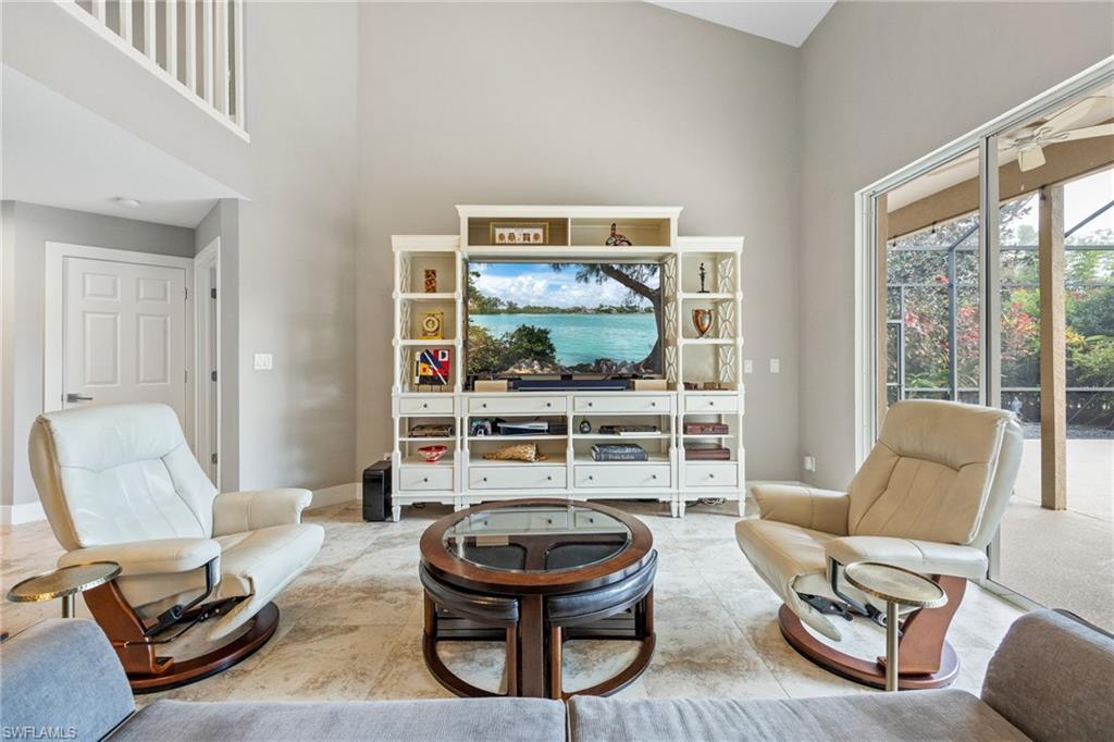 5188 Mabry Drive Naples, FL 34112 - Photo 11 of 49 a living room with furniture a flat screen tv and a floor to ceiling window