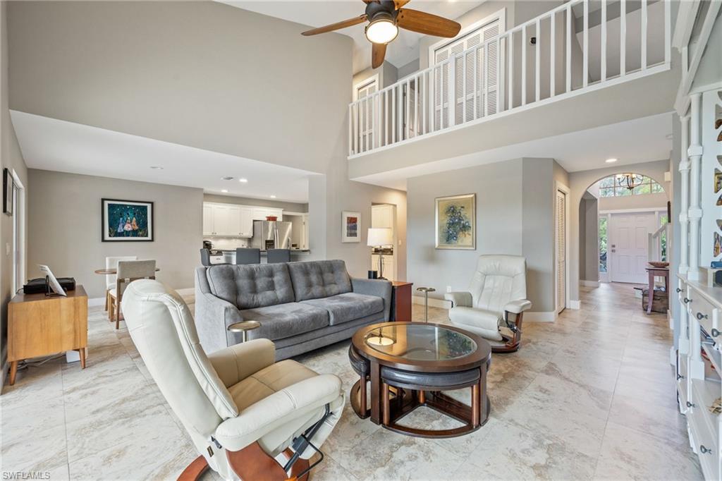 5188 Mabry Drive Naples, FL 34112 - Photo 12 of 49 a living room with furniture a wooden floor and a chandelier