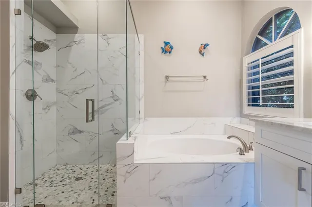 a white bath tub sitting next to a shower