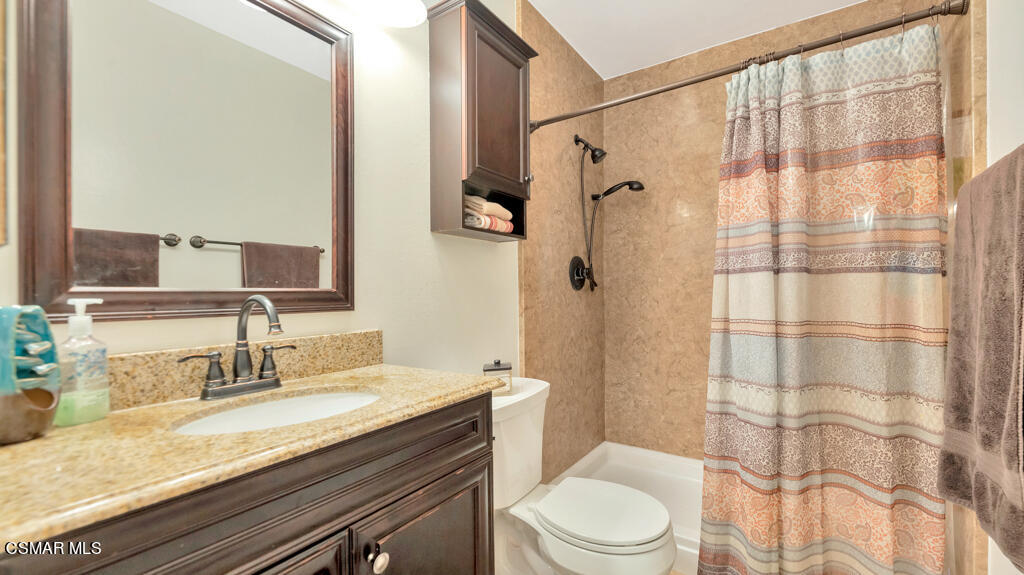 152 Ripley Street Camarillo, CA 93010 - Photo 16 of 36 a bathroom with a granite countertop sink toilet a mirror a vanity and shower