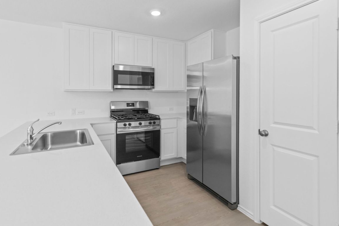 245 Ammolite Lane Maxwell, TX 78656 - Photo 11 of 17 a kitchen with a refrigerator sink and stove