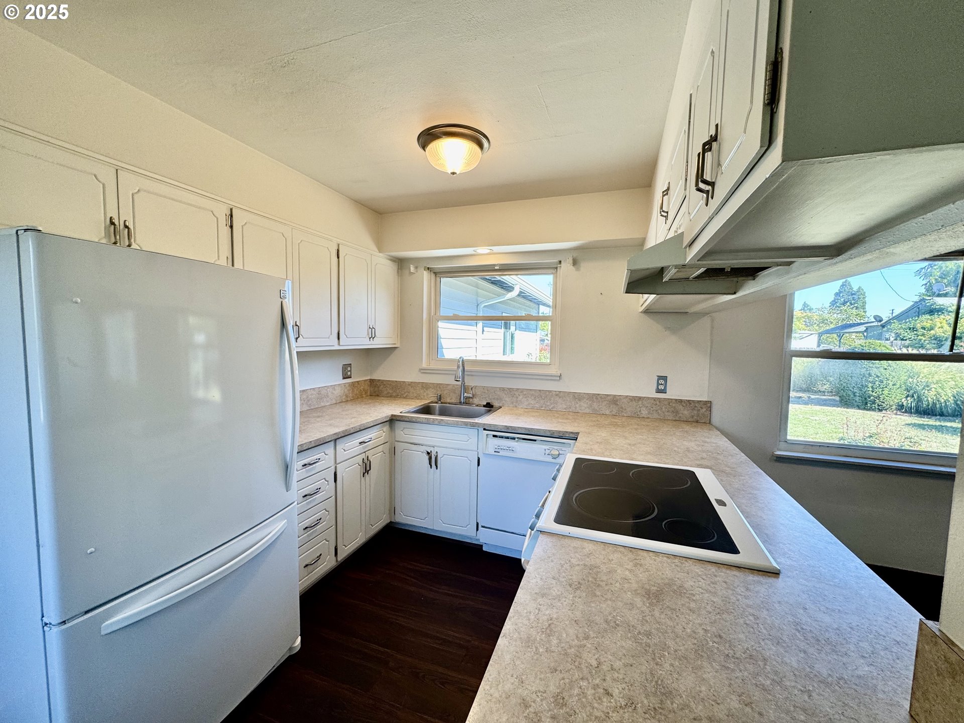1915 Carter Lane Springfield, OR 97477 - Photo 19 of 30 a kitchen with granite countertop a refrigerator a sink and white cabinets