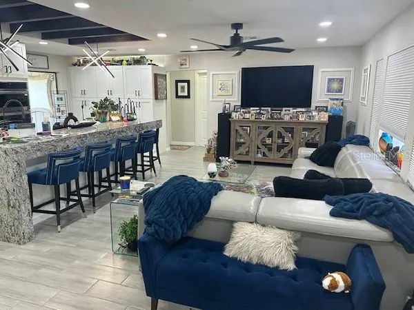 a kitchen with stainless steel appliances granite countertop a table chairs sink and cabinets
