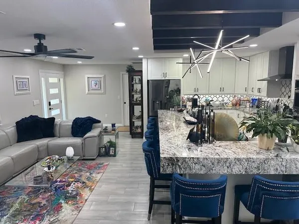 a kitchen with stainless steel appliances granite countertop a refrigerator dining table and chairs