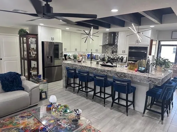 a kitchen with stainless steel appliances granite countertop a table chairs sink and cabinets
