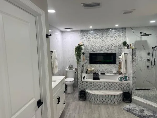 a bathroom with a double vanity sink toilet and shower