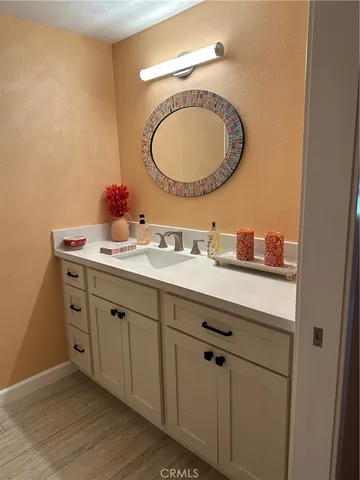 a bathroom with a granite countertop double vanity sink and a mirror