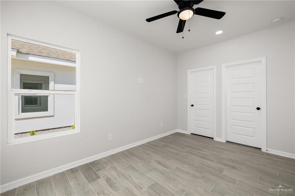196 Farrell Road, Unit 2 Weslaco, TX 78596 - Photo 4 of 12 a view of an empty room with wooden floor and a window