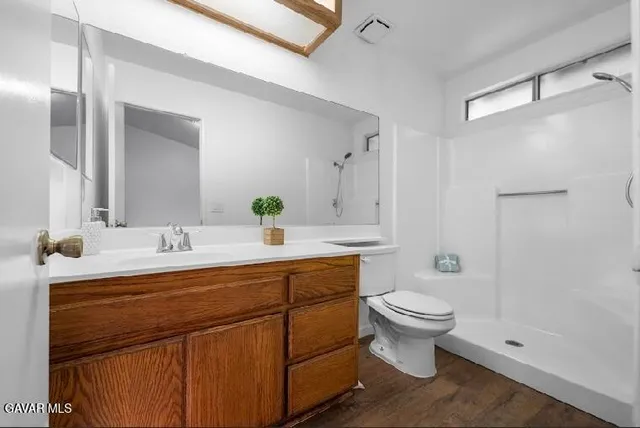 a bathroom with a double vanity sink toilet and a mirror