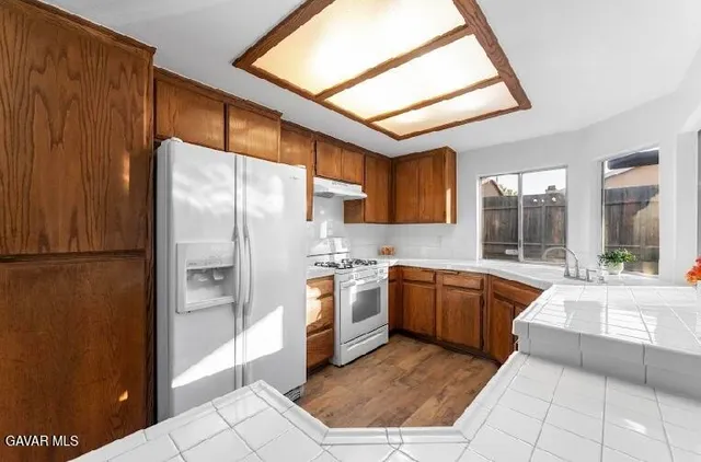a large kitchen with stainless steel appliances granite countertop a refrigerator and a sink
