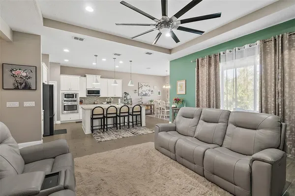 a kitchen with stainless steel appliances a table chairs refrigerator and cabinets