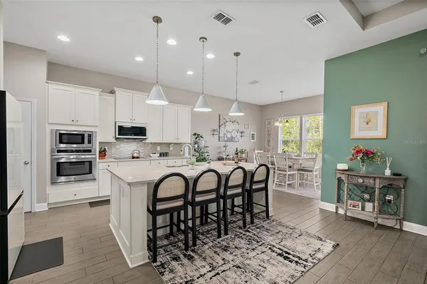 a living room with kitchen island furniture and a view of kitchen
