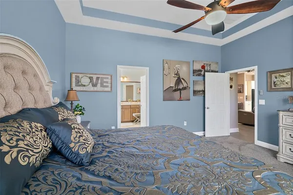 a bedroom with a bed and a lamp on dresser