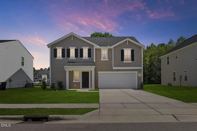 a front view of a house with a yard and garage
