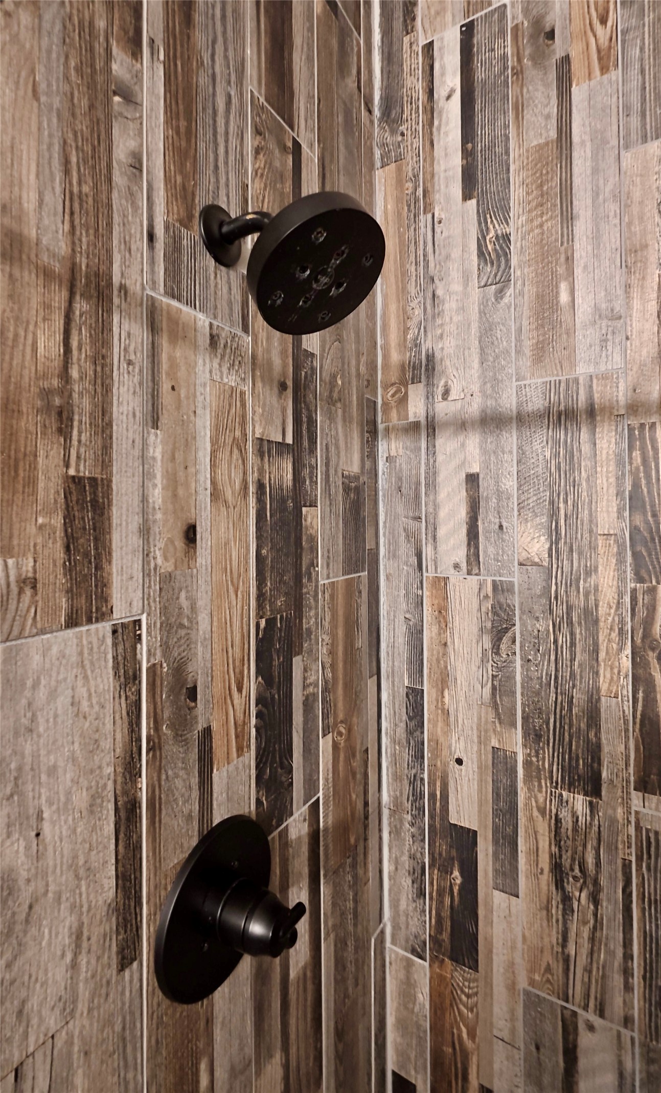 114495 South 4296th Road Porum, OK 74455 - Photo 26 of 59 Shower featuring multi-toned wood-look tile, a matte black rain shower head, and coordinating matte black shower controls