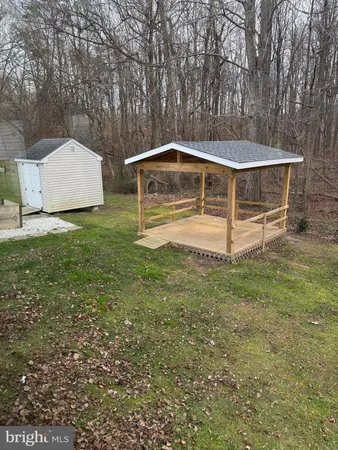 a view of wooden house with a small yard