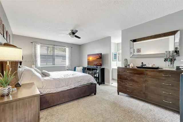 a bedroom with a bed and a dresser next to a window