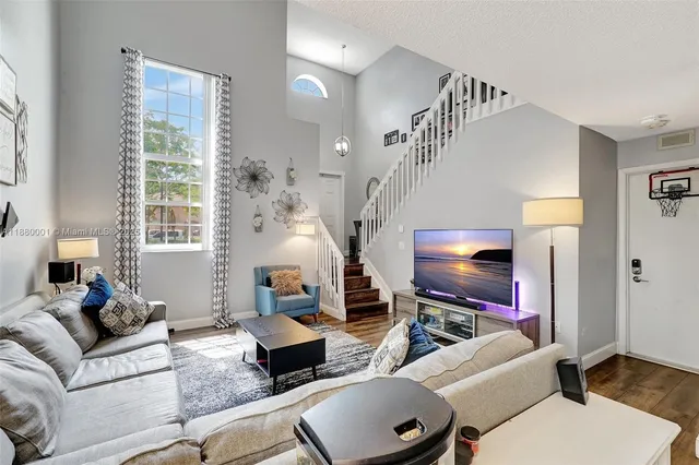 a living room with furniture wooden floor and a flat screen tv