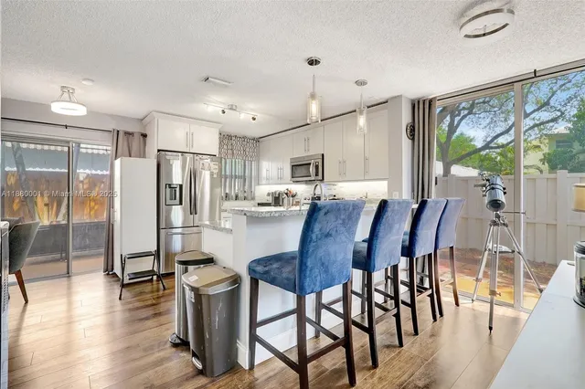 a kitchen with stainless steel appliances granite countertop a refrigerator stove microwave and sink