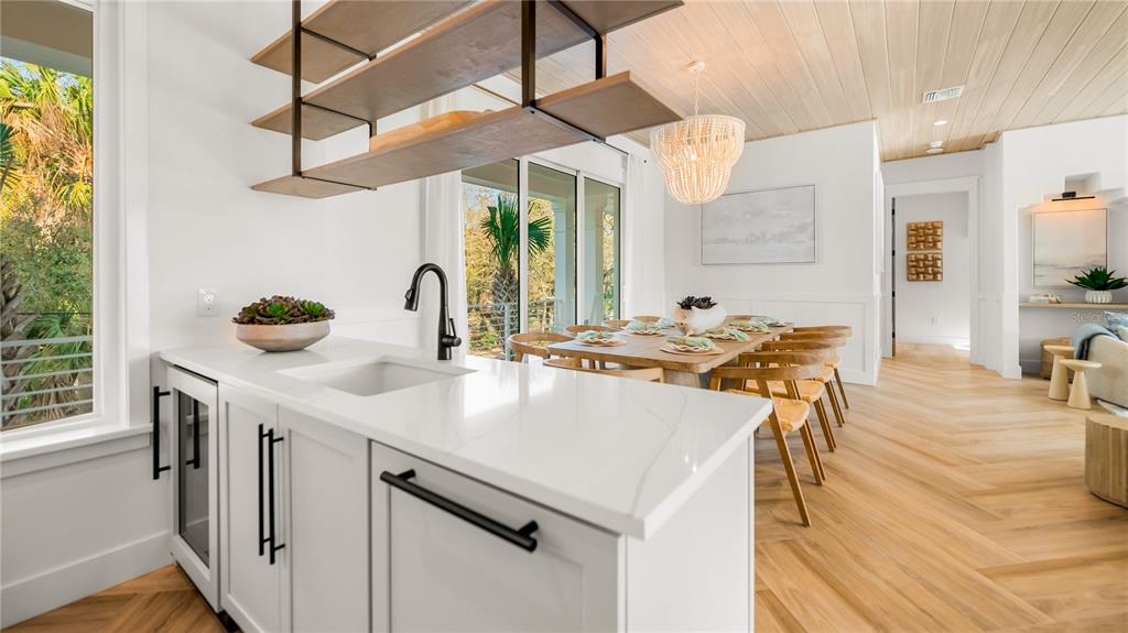 6536 Peacock Road Sarasota, FL 34242 - Photo 25 of 82 a kitchen with a table chairs and a wooden floor