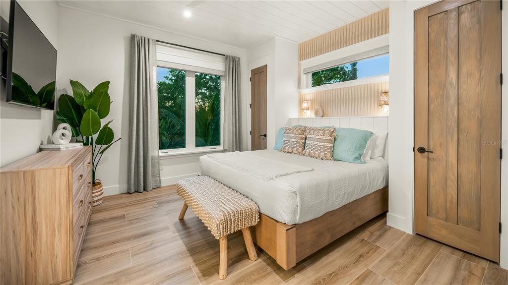 6536 Peacock Road Sarasota, FL 34242 - Photo 53 of 82 a bedroom with a bed window and wooden floor